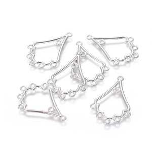 May include: Several silver-colored, fan-shaped jewelry findings. Each finding has a teardrop shape with a scalloped edge and multiple small loops for attaching beads or other components. The findings are designed for jewelry making.