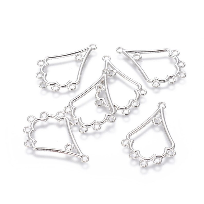 May include: Several silver-colored, fan-shaped jewelry findings. Each finding has a teardrop shape with a scalloped edge and multiple small loops for attaching beads or other components. The findings are designed for jewelry making.
