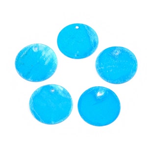 May include: Five round, bright blue pendants with a hole at the top for stringing. The pendants have a textured surface and are arranged against a white background. These pendants are suitable for jewelry making or craft projects.