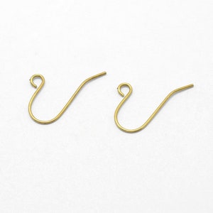 May include: Two gold-colored earring hooks are displayed against a white background. Each hook has a curved, looped top and a straight, pointed bottom. The hooks are designed for jewelry making and are suitable for creating earrings.