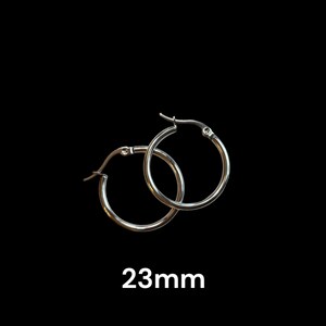 Peut inclure: Une paire de boucles d'oreilles cr&eacute;oles argent&eacute;es, chacune avec un design circulaire simple. Les boucles d'oreilles mesurent 2,3 cm de diam&egrave;tre et sont pr&eacute;sent&eacute;es sur fond noir. Le texte "23mm" est affich&eacute; en dessous.