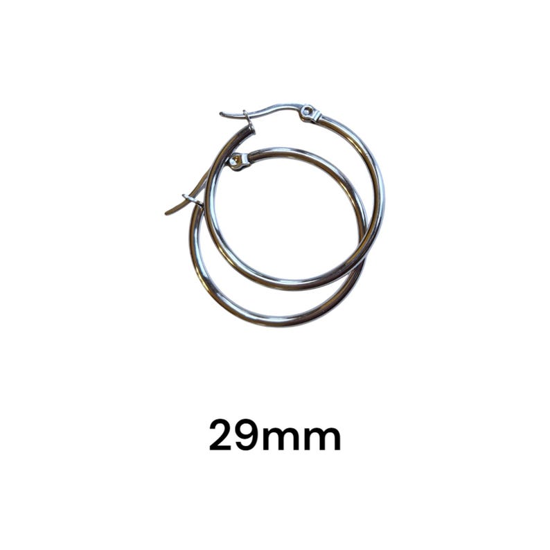 Peut inclure: Une paire de boucles d'oreilles cr&eacute;oles argent&eacute;es. Les boucles d'oreilles mesurent 29 mm de diam&egrave;tre. Les cr&eacute;oles sont rondes et ont un design simple et classique. Fond blanc.