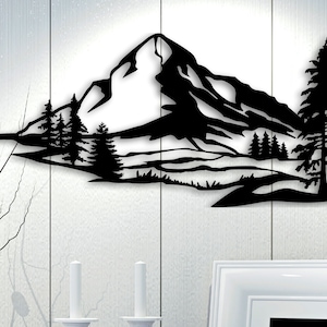 May include: Black metal wall art depicting a mountain range with a tall pine tree in the foreground. The mountain range is silhouetted against a white background.