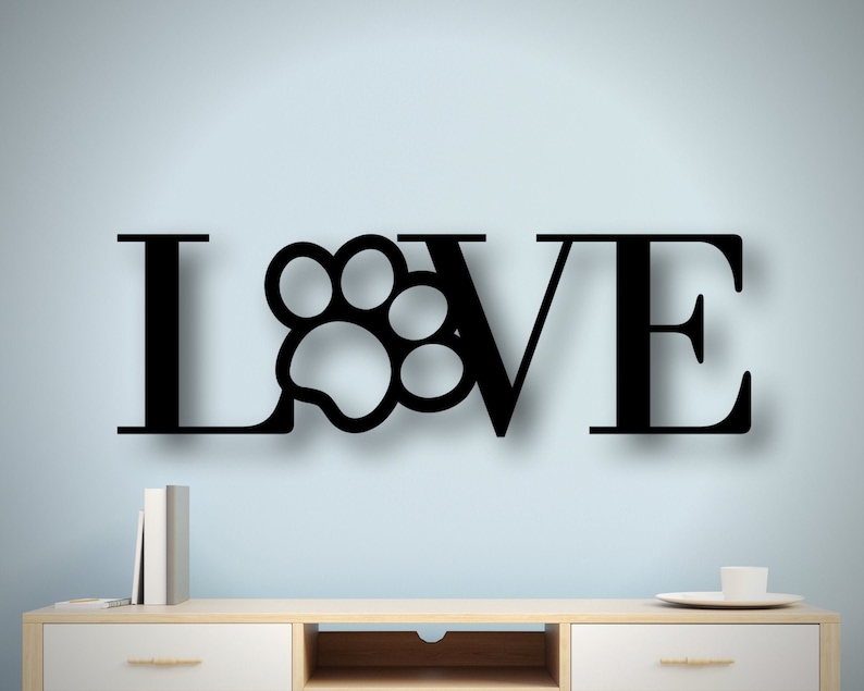 May include: Black metal wall decor with the word "LOVE" with a paw print in place of the "O".