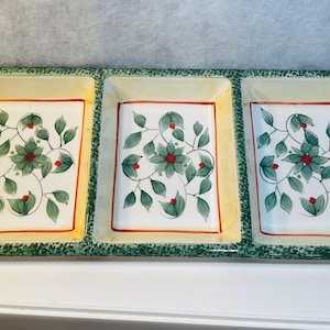 Puede incluir: Una fuente rectangular con tres compartimentos. Cada compartimento tiene un fondo blanco con un diseño floral en verde, rojo y amarillo. La fuente tiene un borde verde y un ribete amarillo.