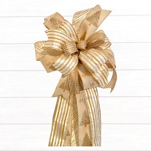 May include: A gold and white striped Christmas tree topper bow with a burlap texture and gold glitter accents.