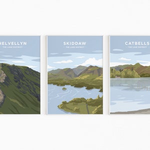 May include: Three minimalist landscape prints featuring scenic views of the Lake District in England. The prints are titled "Helvellyn", "Skiddaw", and "Catbells" and each includes the text "The Lake District".