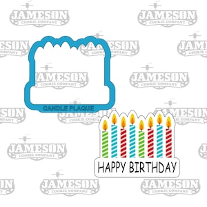 May include: A blue cookie cutter shaped like a cake with candles. The cutter is next to a design for a cookie with the words "Happy Birthday" and seven candles with green, blue, and red stripes.