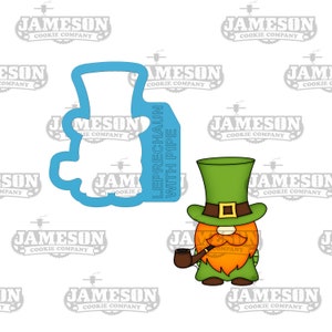 May include: A green leprechaun cookie cutter with a red beard and a pipe, next to a matching outline. The text "LEPRECHAUN WITH PIPE" is on the outline. The leprechaun wears a green hat and coat.