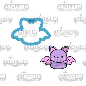 May include: A blue cookie cutter in the shape of a bat with the word "BAT" written on it. A purple cartoon bat with pink wings is shown next to the cutter.