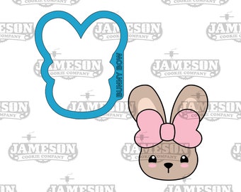 May include: A blue cookie cutter shaped like a bunny with a bow. The cutter is next to a cartoon image of a bunny with a pink bow and brown ears. The bunny has a brown face with black eyes and a black nose.