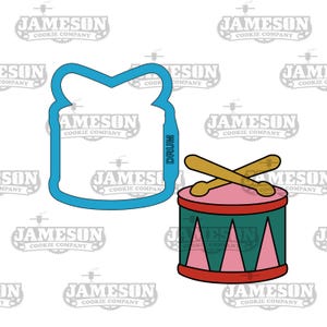 May include: A blue cookie cutter shaped like a drum with two drumsticks crossed over the top. The drum has a red rim, a green body, and a pink drumhead with a white triangle pattern.