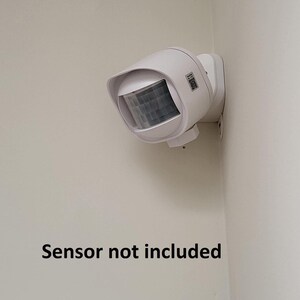 May include: White motion sensor light fixture mounted on a white wall. The sensor is not included. "Sensor not included" text is visible in the image.