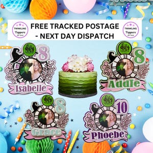 May include: Four custom cake toppers featuring a clock face design, a witch hat, floral accents, and a central circular photo frame. Each topper displays a name and a number, including Isabelle 8, Addie 8, Grace 8, and Phoebe 10, with glittery finishes.