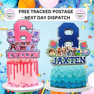 May include: Two birthday cakes with toppers. One cake is pink with a pink number 6 topper and the name "EVELYN". The other cake is blue with a blue number 8 topper and the name "JAXTEN". The toppers have cartoon characters.