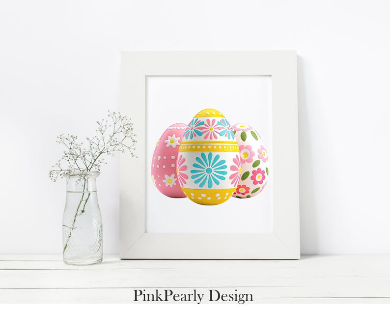 May include: A white framed print featuring three decorative Easter eggs. The eggs are painted with floral and geometric patterns in pink, yellow, and blue. The text "Pink Pearly Design" is at the bottom of the frame.