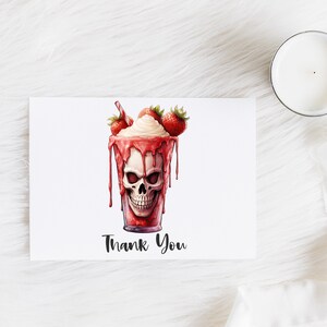 May include: A thank you card featuring a red and white strawberry milkshake with a skull face and the words "Thank You" printed on the card.