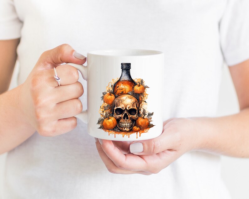 May include: White ceramic mug featuring a Halloween design. The design depicts a skull with a bottle of liquid and pumpkins.