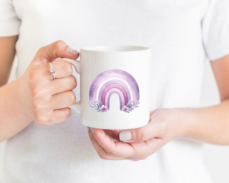 May include: White ceramic mug with a purple and pink watercolor rainbow design with flowers and leaves.