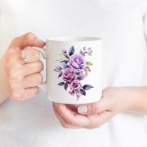 May include: White ceramic mug with a purple floral design. The flowers are watercolor style and include roses and leaves.
