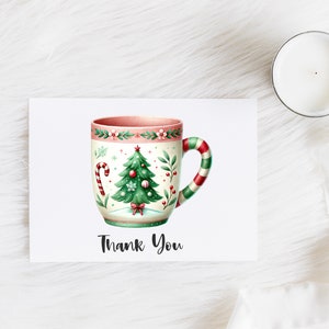 May include: A greeting card with a watercolor illustration of a Christmas-themed mug. The mug features a Christmas tree, candy cane, and floral details. The handle is striped red and green. The words "Thank You" are written below the mug.