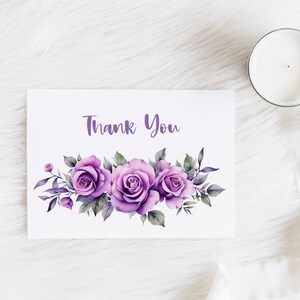 May include: A white card with the text "Thank You" printed in purple. The card is decorated with a cluster of purple watercolor roses and green leaves.