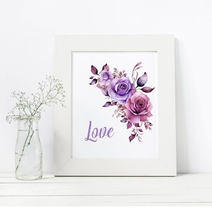 May include: A white frame with a watercolor painting of purple and pink roses with green leaves. The word "Love" is written in purple below the flowers.