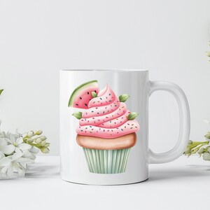 May include: White ceramic mug featuring a watercolor illustration of a cupcake with pink frosting, sprinkles, and a watermelon slice. The cupcake sits on a light green cupcake liner. The mug has a white handle and is surrounded by white flowers.