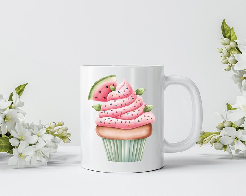 May include: White ceramic mug featuring a watercolor illustration of a cupcake with pink frosting, sprinkles, and a watermelon slice. The cupcake sits on a light green cupcake liner. The mug has a white handle and is surrounded by white flowers.