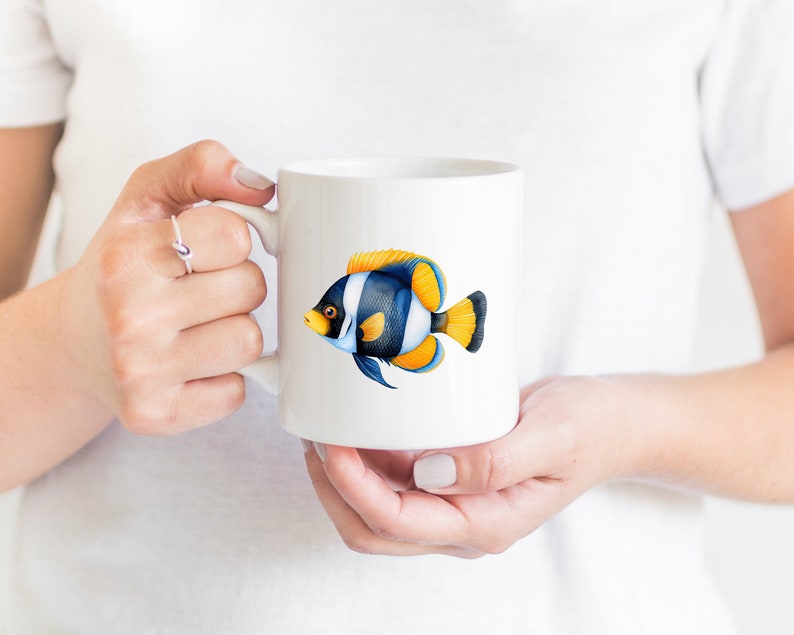 May include: White ceramic mug with a colorful illustration of a blue, yellow, and white fish. The fish has black stripes and yellow fins.