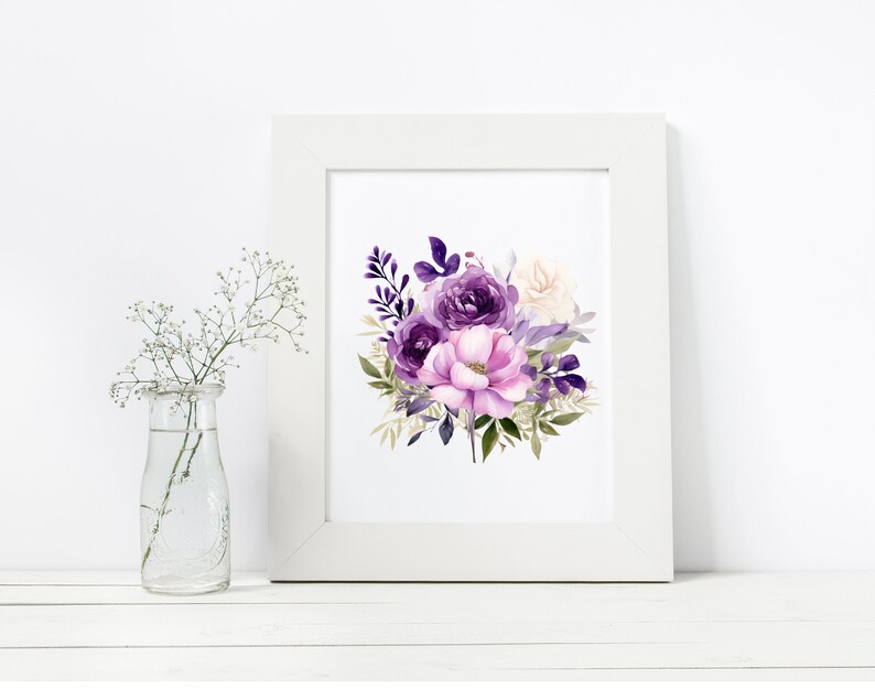 May include: A framed floral print showing a watercolour bouquet of purple and pink flowers, including roses and other blooms with green foliage. The print is in a white frame. A small glass vase with white flowers is to the left.