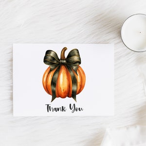 May include: A thank you card with a watercolor illustration of an orange pumpkin with a black bow. The text "Thank You" is printed below the pumpkin.
