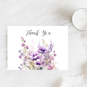 May include: A white card with the text "Thank You" printed in black cursive script. The card is decorated with a watercolour illustration of a bouquet of purple and pink flowers.