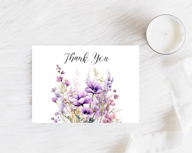 May include: A white card with the text "Thank You" printed in black cursive script. The card is decorated with a watercolour illustration of a bouquet of purple and pink flowers.