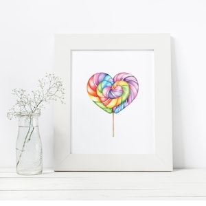 May include: A white framed print of a colorful heart-shaped lollipop on a stick. The lollipop is made of swirls of pink, purple, blue, green, and yellow.
