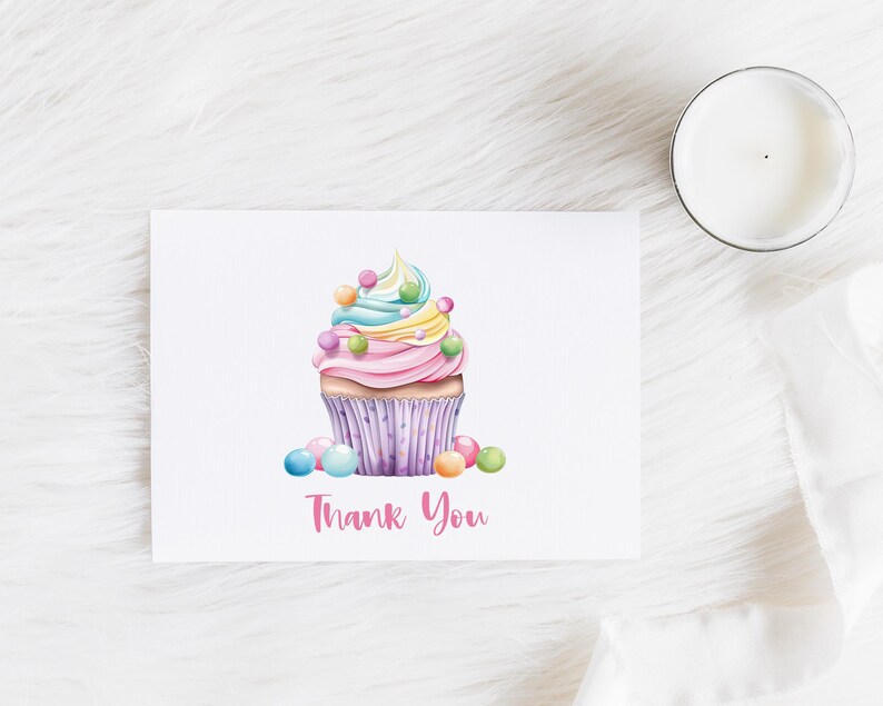 May include: A pink and white cupcake with rainbow frosting and colorful sprinkles. The cupcake is on a white background with the text "Thank You".