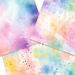 Op de afbeelding: Drie vellen aquarelpapier met verschillende abstracte ontwerpen. Het eerste vel heeft een lichtblauw, roze en paars aquarelontwerp. Het tweede vel heeft een lichtgeel, roze en groen aquarelontwerp met gouden glitter. Het derde vel heeft een lichtblauw, geel en roze aquarelontwerp met rode en blauwe stippen.