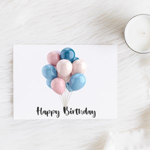 May include: A white greeting card with the text "Happy Birthday" in black script. The card features a cluster of pastel-colored balloons in shades of pink, blue, and teal. A white candle sits to the right.