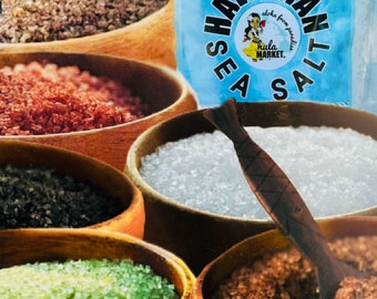 May include: Six wooden bowls filled with different types of Hawaiian sea salt. The bowls are arranged in a semi-circle. The salt is in various colors, including white, brown, green, and red. A wooden spoon is in the center of the image. The label on the bag reads "Hawaiian Sea Salt, Aloha from paradise, Hula Market."