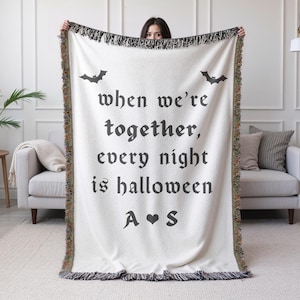 May include: Cream-colored throw blanket with black text and bat graphics. The text reads "when we're together, every night is halloween" with initials "A ♥ S". The blanket has a fringed edge.