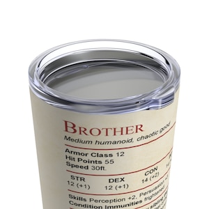 May include: A white tumbler with a brown label that reads "BROTHER" in red text. The label also includes the text "Medium humanoid, chaotic good" and stats for a character with the name "Brother".