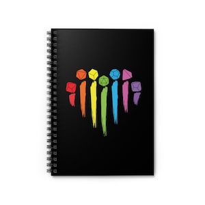 May include: A black spiral notebook with a rainbow design featuring dice. The dice are arranged in a heart shape and are outlined in black. The rainbow colors are red, orange, yellow, green, blue, indigo, and violet.