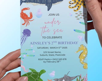 May include: An invitation with an underwater theme, featuring illustrations of sea creatures like a shark, crab, and seahorse. The text reads "Join us under the sea to celebrate Ainsley's 2nd Birthday."
