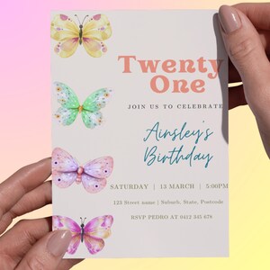 Puede incluir: Una invitación de cumpleaños con tema de mariposas. La invitación dice "Twenty One" y "Ainsley's Birthday". El diseño presenta mariposas de acuarela en amarillo, verde, rosa y morado. Incluye fecha, hora e información de RSVP.