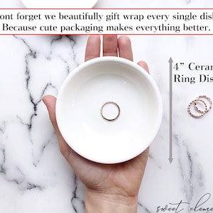May include: A white ceramic ring dish, 4 inches in diameter, with a gold ring inside. The dish is being held in a hand, and the text "4" Ceramic Ring Dish" is visible in the image.