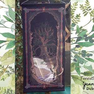 Op de afbeelding: Een wandkleed met een donkere achtergrond waarop een grote boom met wortels en een beek die door het bos stroomt. Het wandkleed heeft een rode, groene en gouden rand met Keltische knoopontwerpen. De tekst "Forestheart Gennick Dubois" is zichtbaar onderaan het wandkleed.