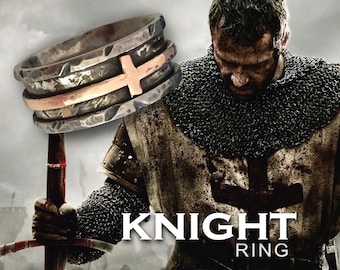 May include: A silver and copper ring with a cross design. The ring is worn by a knight in chainmail armor. The text "KNIGHT RING" is visible below the ring.