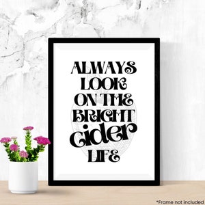 May include: Black and white typography print with the text "Always look on the bright cider life". The print is framed in a black frame and is displayed on a white surface.
