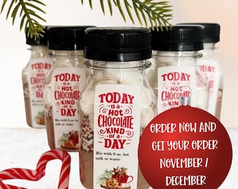 May include: Clear plastic bottles with black caps filled with hot chocolate mix and marshmallows. Each bottle features a white label with red text reading Today is a hot chocolate kind of a day and instructions to mix with 8 oz. hot milk or water.