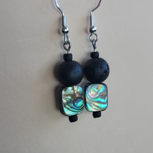 May include: A pair of earrings with black lava rock beads and iridescent abalone shell squares.